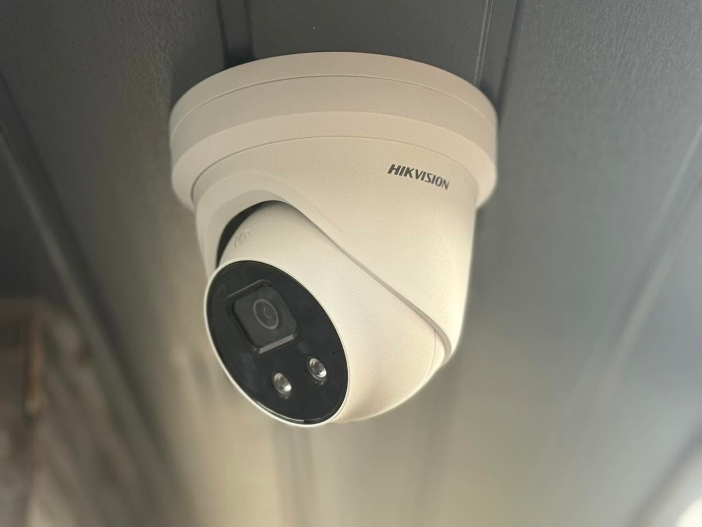 Close-up of a white Hikvision CCTV dome camera mounted under a soffit, installed by Gunning Electrical Services