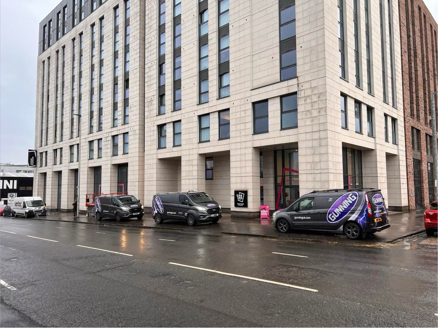 Three Gunning Electrical Services vans parked outside a commercial fit-out in Glasgow city centre
